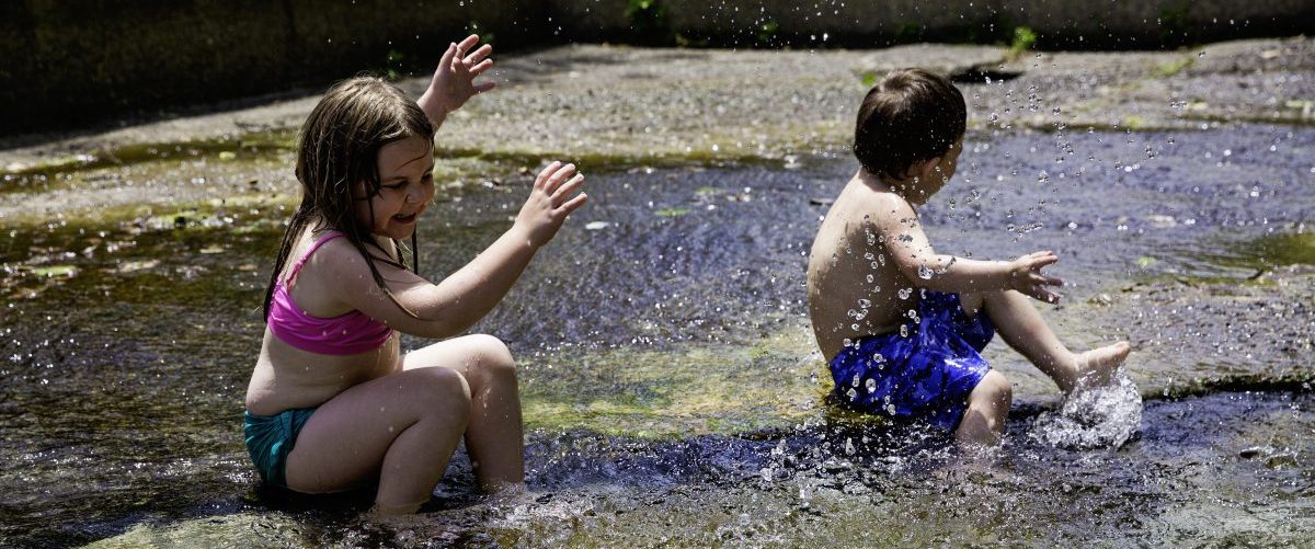 Boy and girl playing in water hole, West Virginia