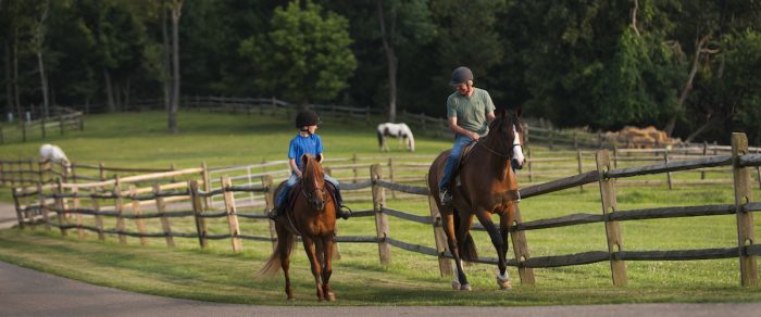 Young boy and father riding horses in West Virginia