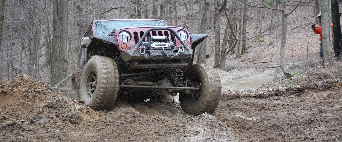 Jeep Wrangler climbing up muddy slope in West Virginia
