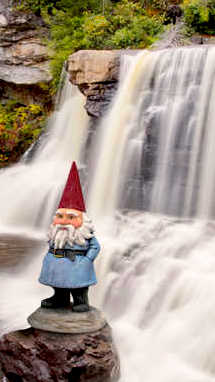The gnome stands in front of Blackwater Falls, WV