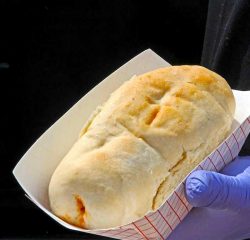 Vendor holding a boxed pepperoni roll, WV
