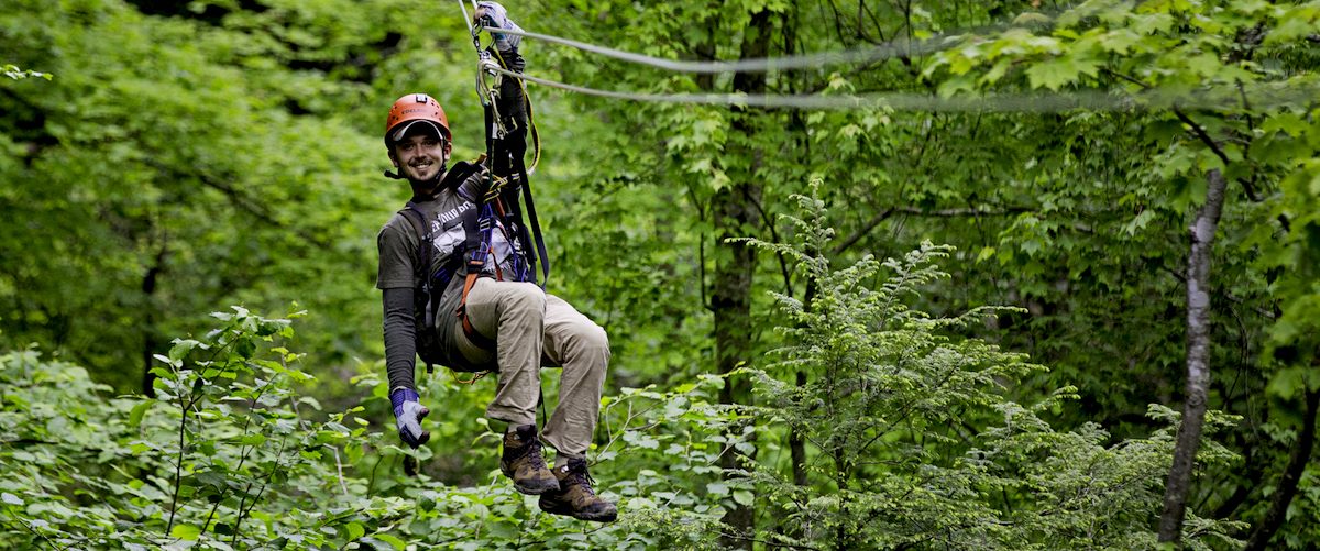 A male zip liner above the forest at Adventures on the Gorge, WV