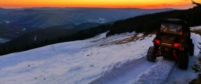 RZR driving through snow along ridge at sunset, Snowshoe Mountain, WV