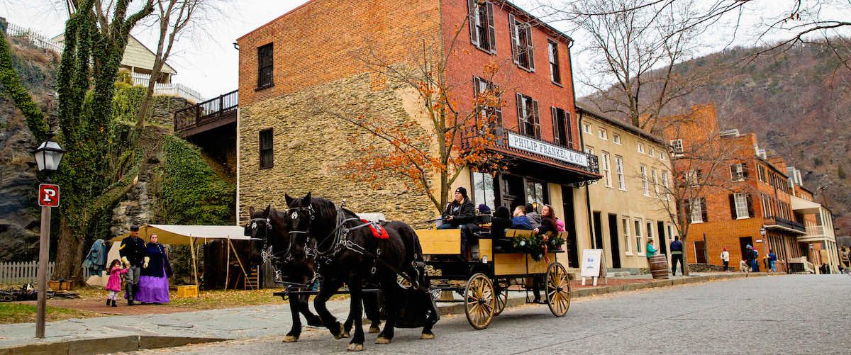 Black horses pull a wagon down historic district at Harpers Ferry, WV