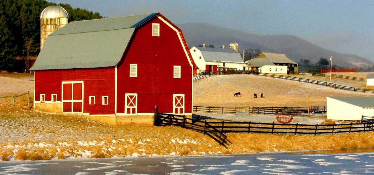 Red barn in a yellow field, bordered by a gray frozen pond, West Virginia
