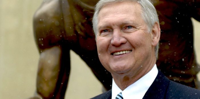 Legendary basketball player Jerry West posing in front of his statue in Charleston, WV
