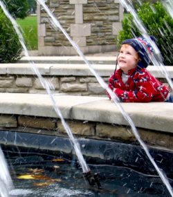 Young boy watches a fountain and gold fish at Ritter Park, WV