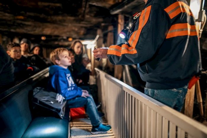 Child listens to veteran coal miner give tour at Beckley Exhibition Coal Mine
