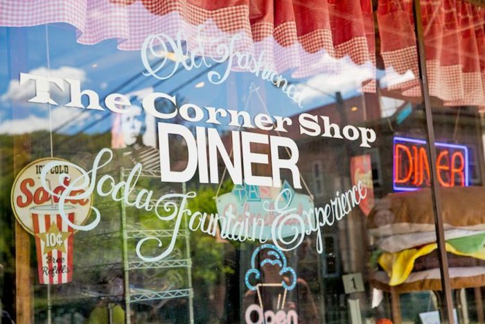 Storefront sign that reads, "The Corner Shop Diner and Soda Fountain Experience"