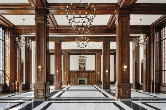 Grand ballroom with tall wood columns chandeliers and patterned floor