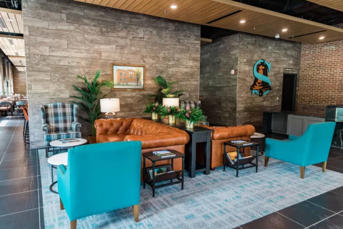 Hotel lobby seating area with leather sofa chairs tables and plants
