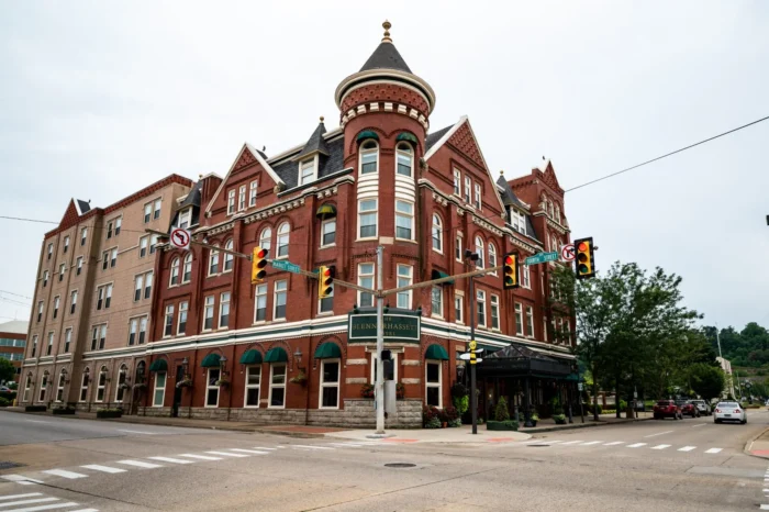 Historic brick hotel with turret at a street corner and traffic lights